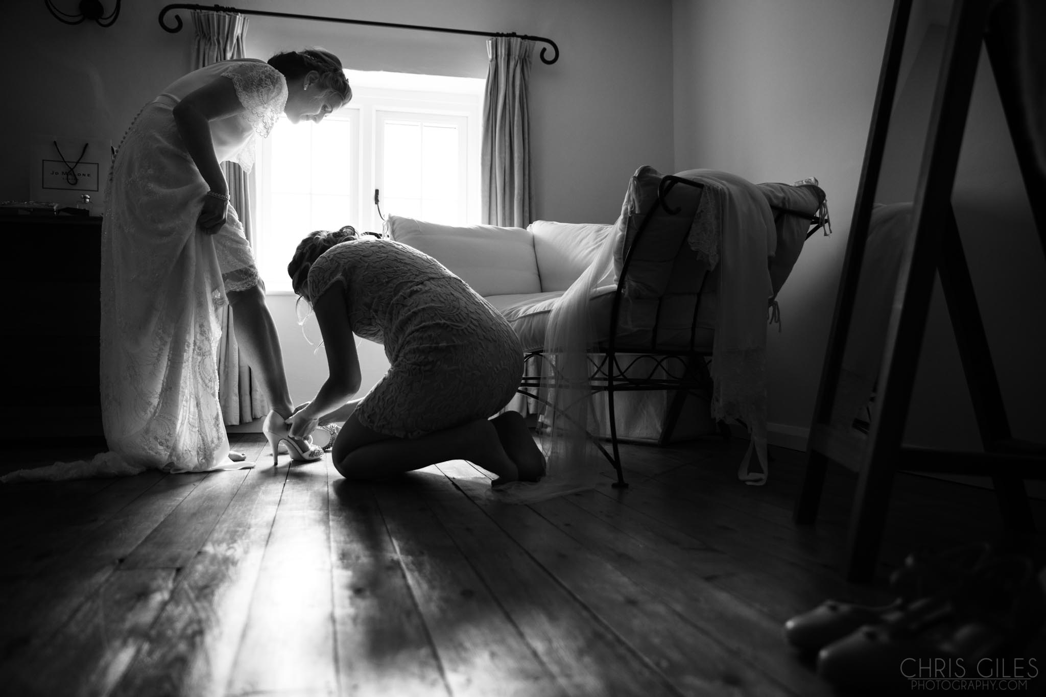 Bride putting on her shoes before heading to Cripps Barn Cirencester