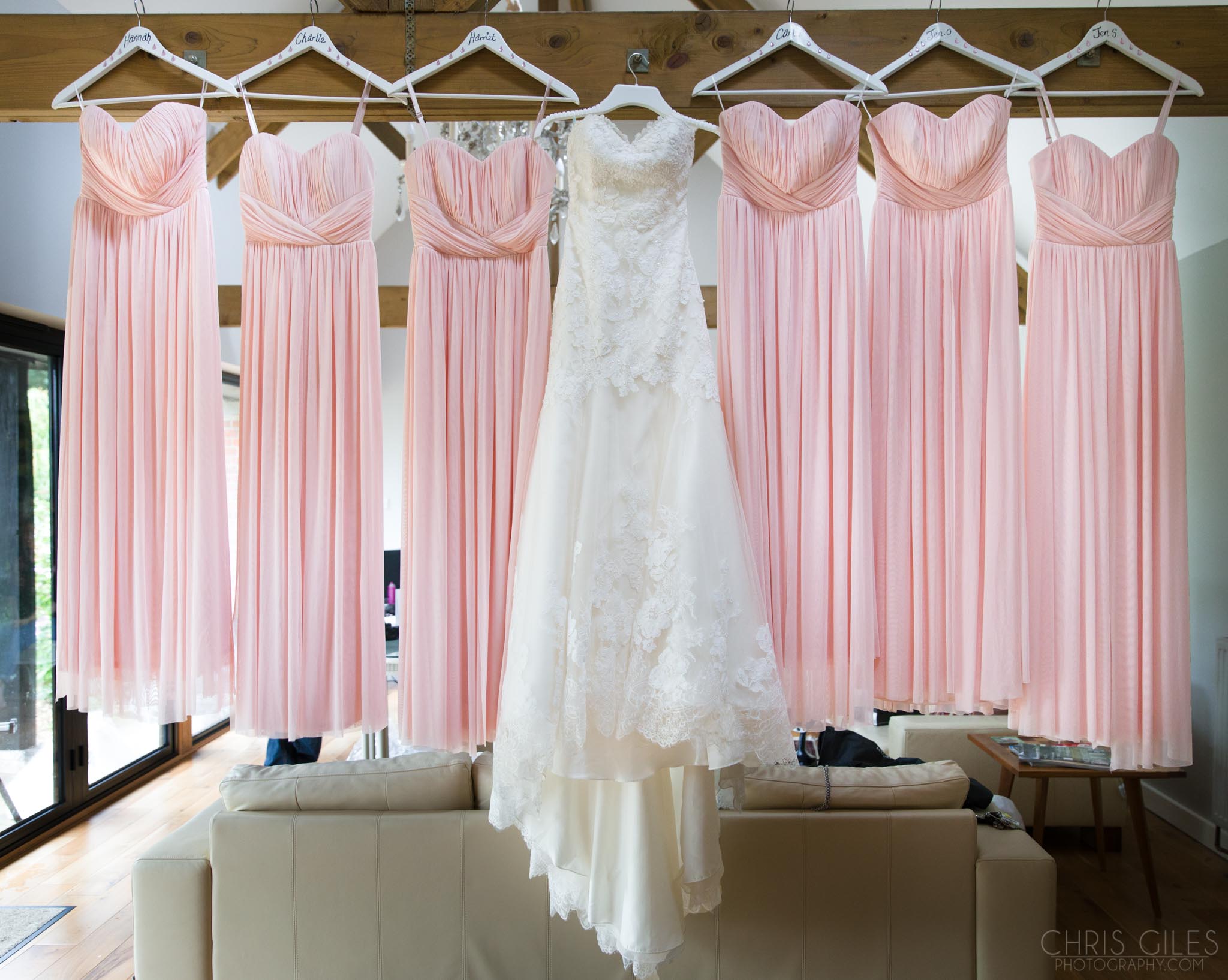 Pastel pink bridesmaids dresses with a white wedding dress in the middle